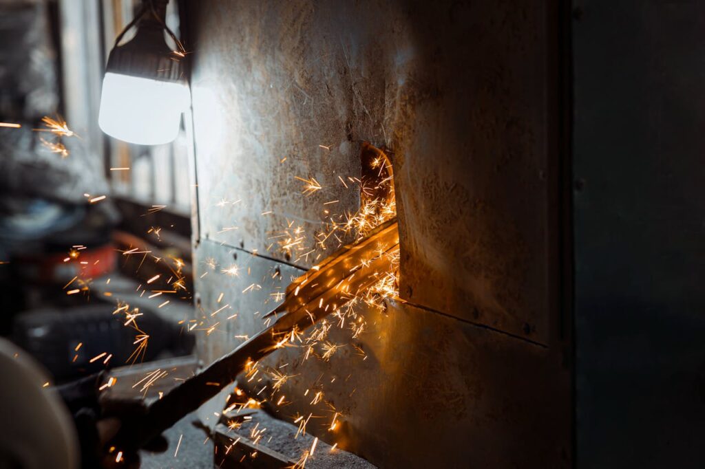 Detailed image of metal grinding with flying sparks in a workshop setting.